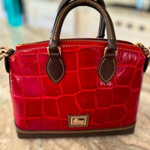 Dooney and Bourke deep red crossbody bag with dark brown accents. Gold hardware.